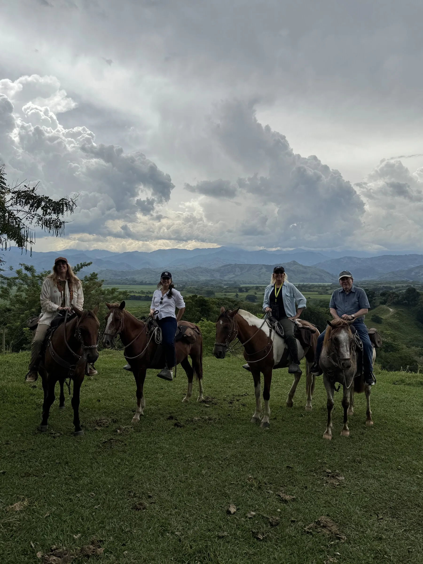 Tres jinetes sobre una loma con cielo dramático